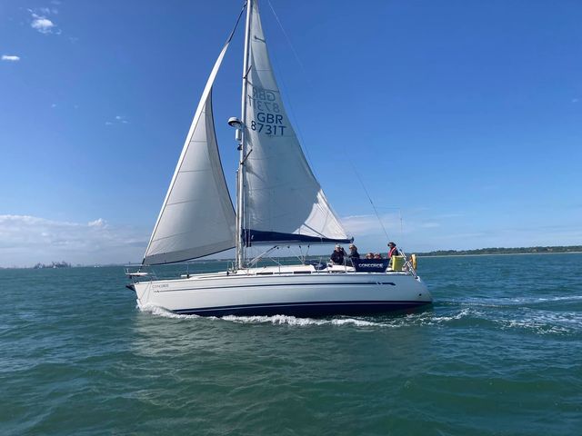 A club yacht under full sail in the Solent